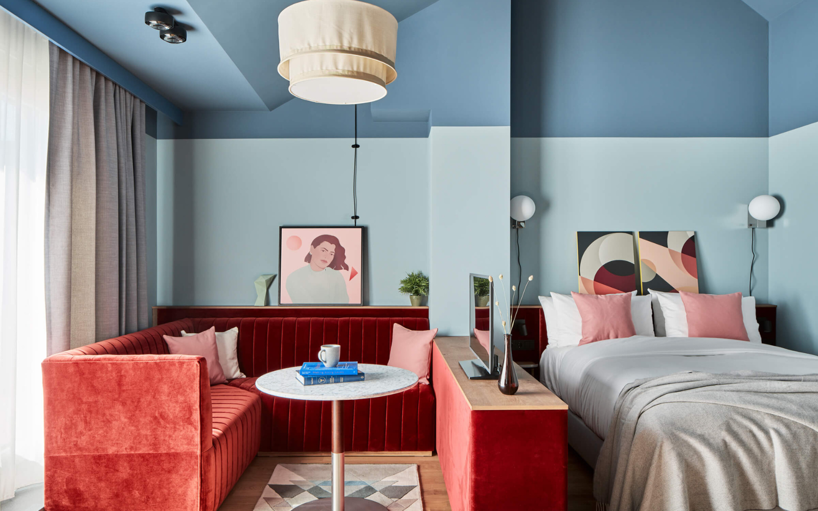 Pale blue walled room at Locke Munich with rust coloured seating area
