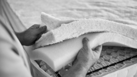 black and white image of layers of mattress fabric being held together by an individual at the Silentnight factory