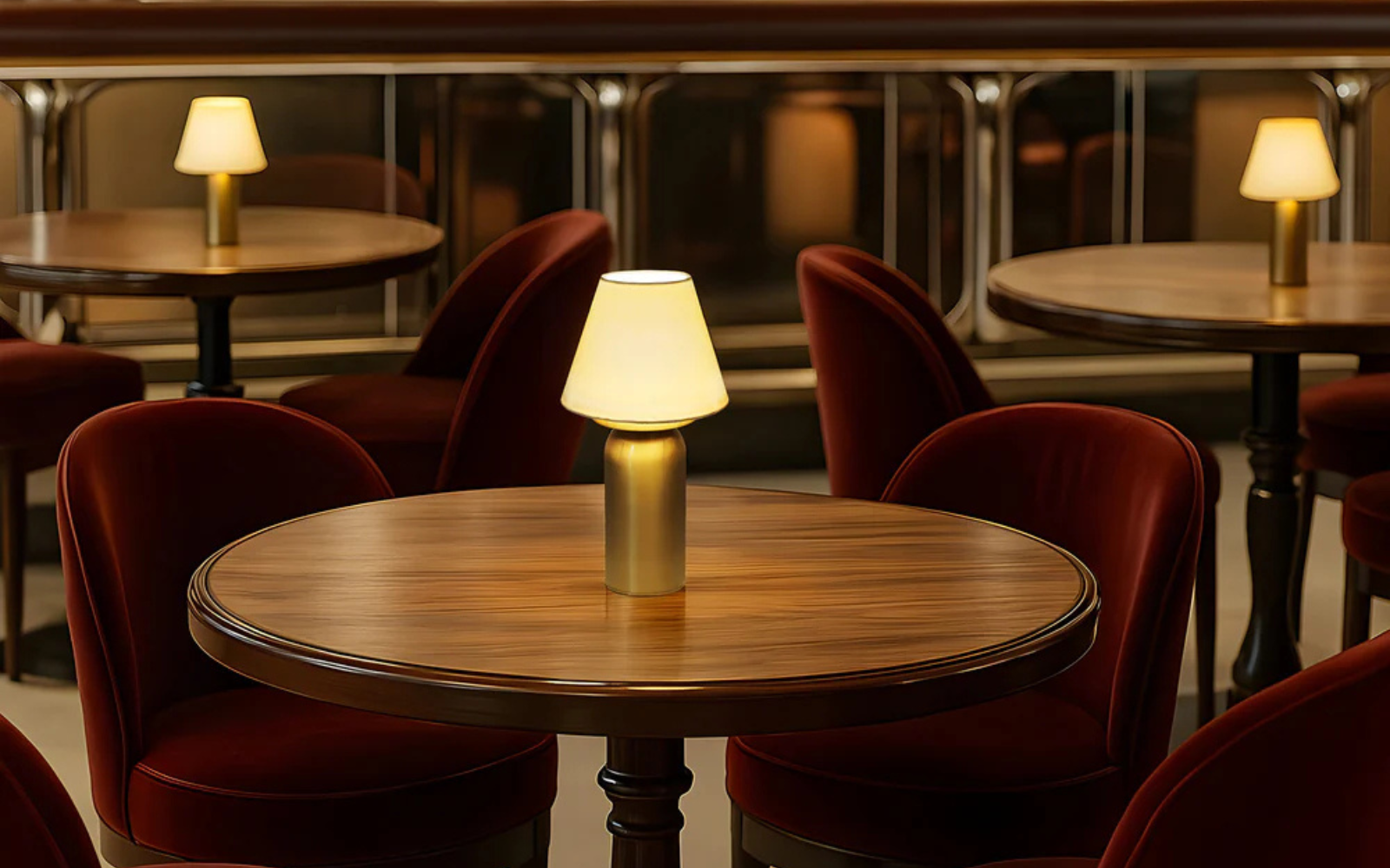 Bubble cordless lighting from Northern Lights, set on round wooden table with burgundy velvet seats surrounding