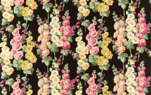 Hollyhocks fabric by Sanderson with black background and repeating pattern of a yellow, pink and cream hollyhock