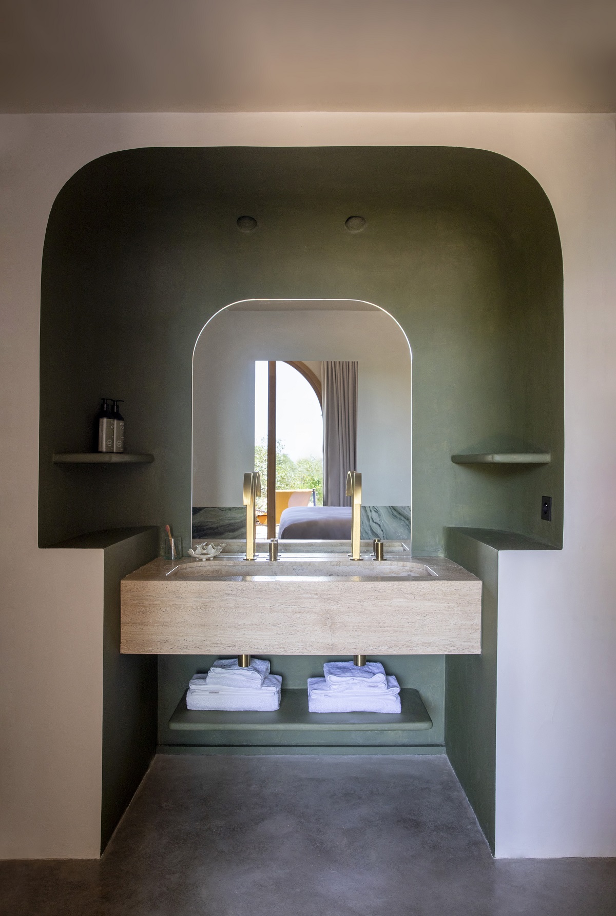 bathroom in Mylos Hotel with arched vanity alcove and view outdoors reflected in mirror