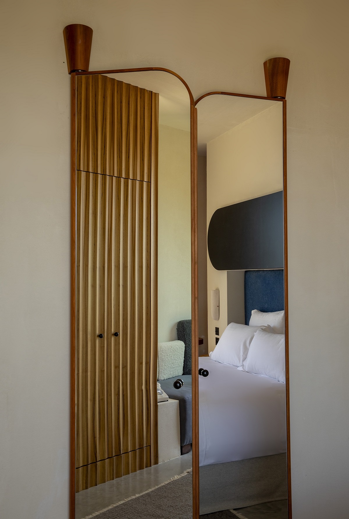 view through wooden door into guestroom in Mylos Hotel in stone and grey