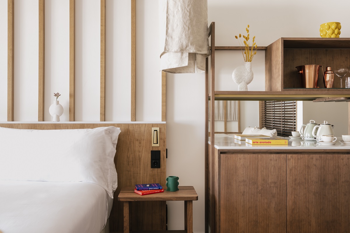 white bed linen and light wood furniture in guestroom