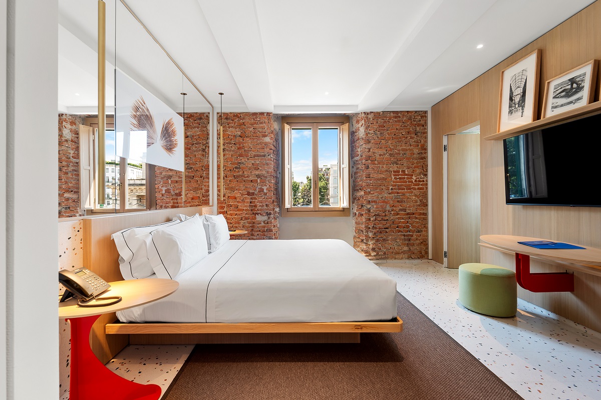 exposed brick and terrazzo floor in hotel guestroom