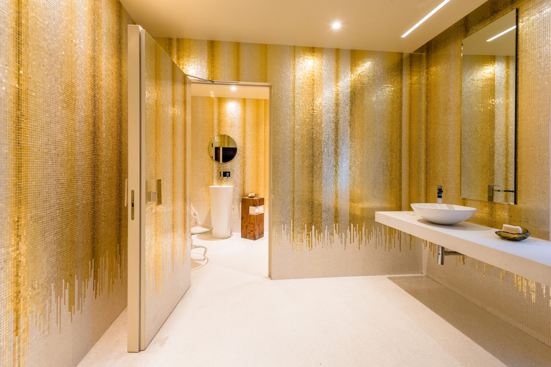 Gold and silver mosaic in bathroom. Gold drips down towards floor. By Orsoni mosaics