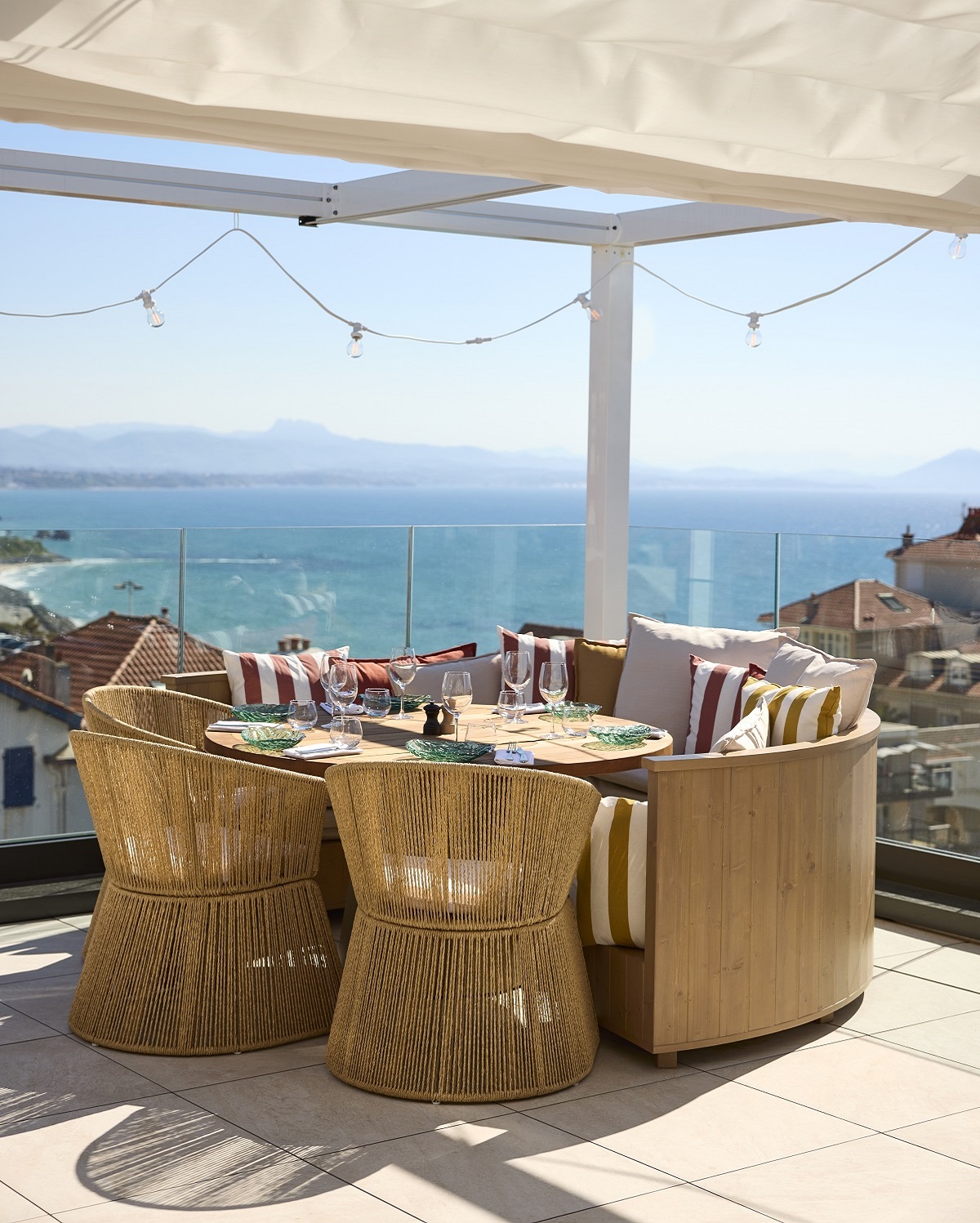table with wicker chairs on roof terrace under shade cloth