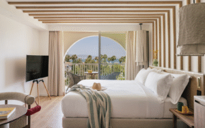double bed in hotel guestroom ME Marbella with arched window and sea view