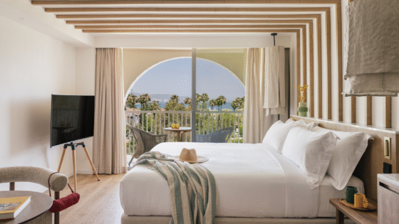double bed in hotel guestroom ME Marbella with arched window and sea view