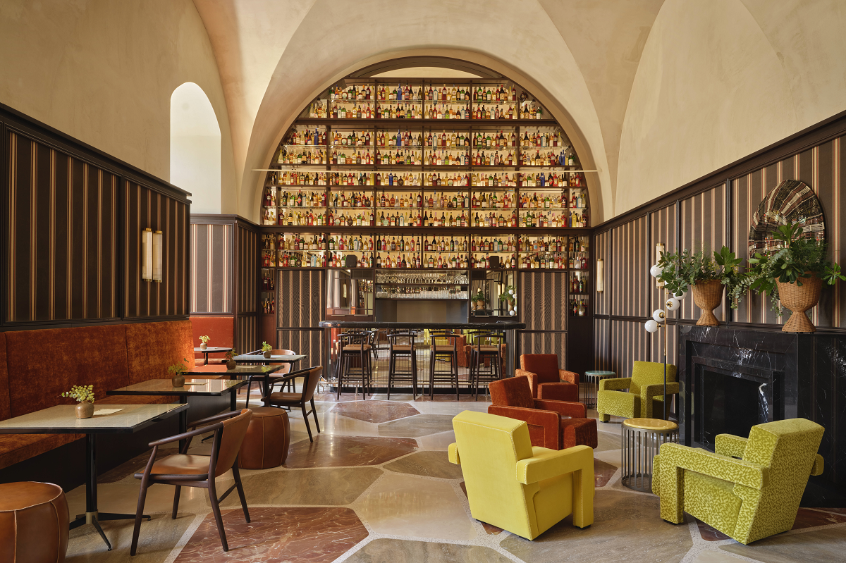 high volume vaulted ceiling above bar counter and shelves with mid century style furniture