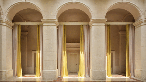 3 arches in cream stone framed with yellow floor to ceiling curtains in Vista Ostuni - a five-star luxury hotel and part of the Vista brand