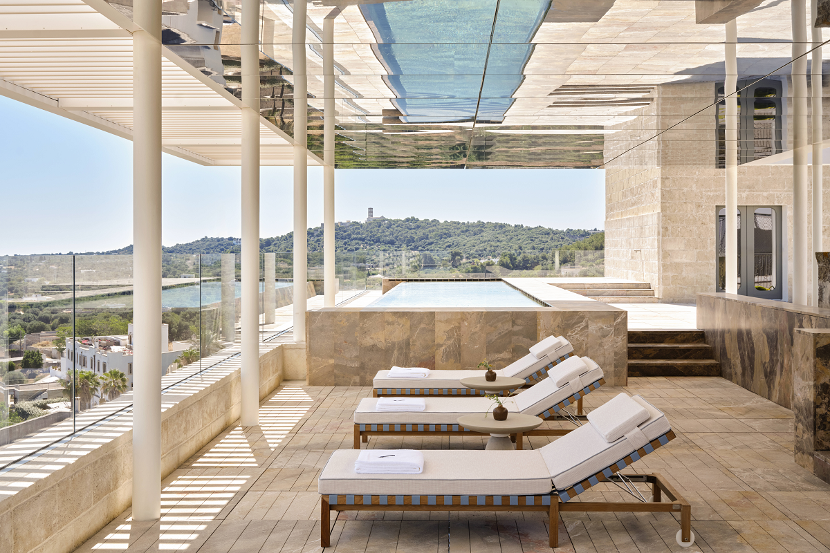 rooftop terrace with loungers and swimming poo overlooking gardens at Villa Ostuni