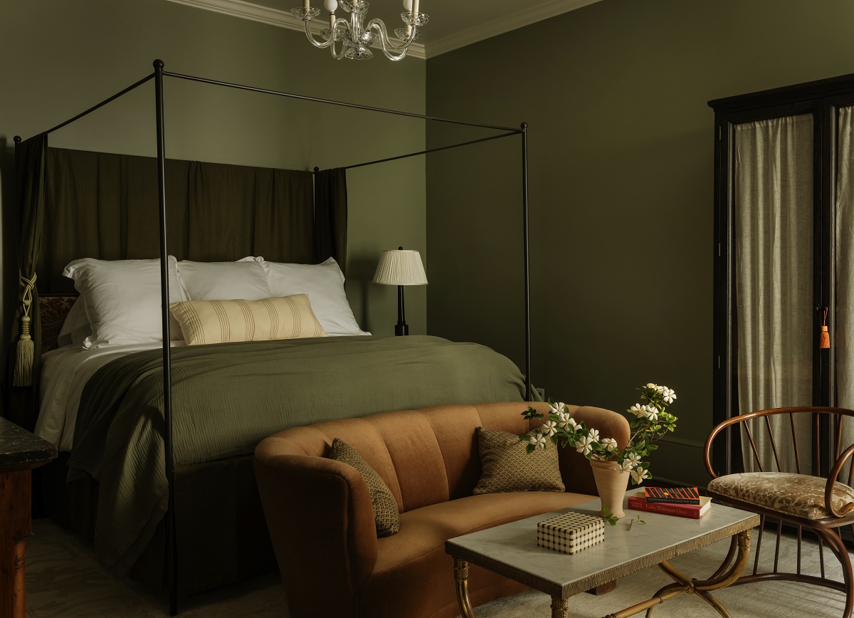 guestroom with four-poster bed under glass chandelier with table and chairs