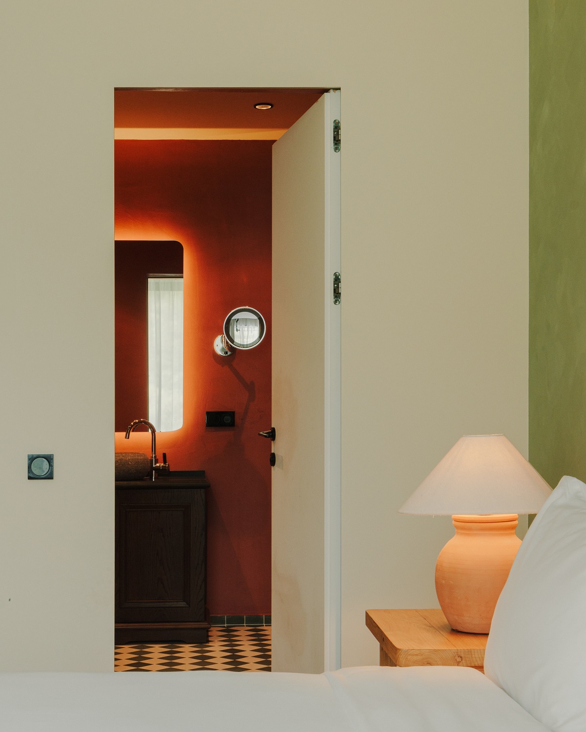 view from green guestroom into terracotta bathroom