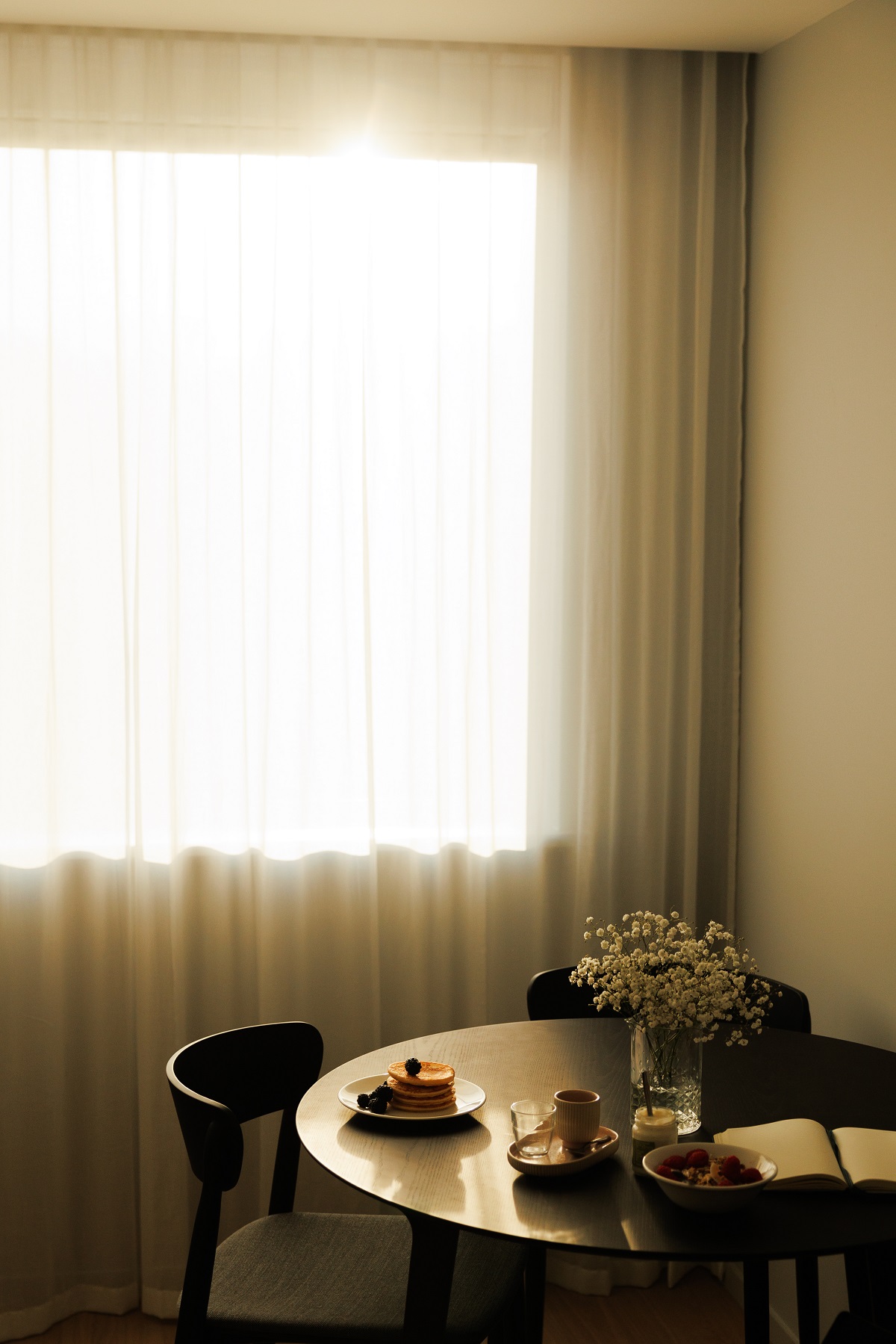round table setting and window with sheer curtain