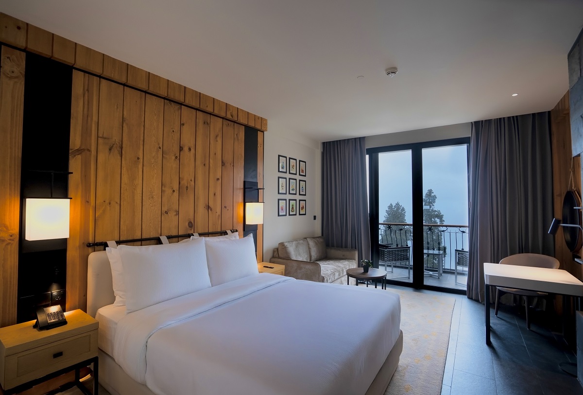 guestroom in DoubleTree hotel in Pakistan with mountain views, white linen and wood panelling