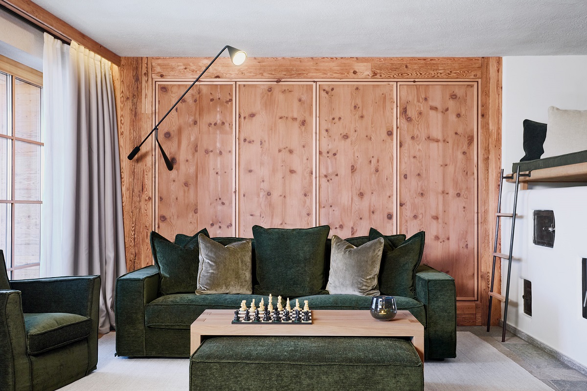green velvet sofa against alpine pine wall cladding with contemporary feature lighting