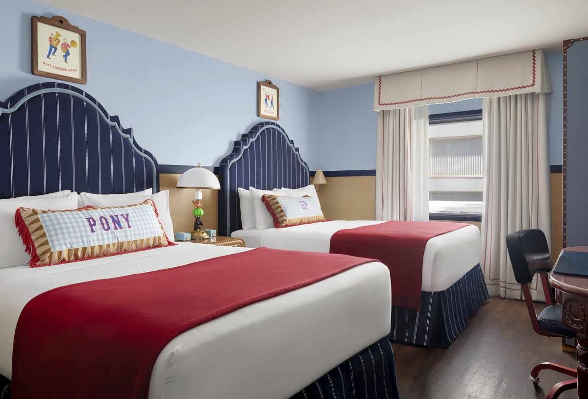 blue striped upholstered bedheads with contrasting red blanket in guestroom at Graduate by Hilton Dallas