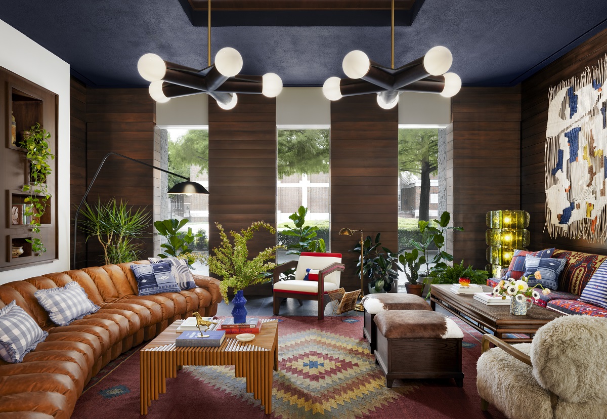 curved leather couch, wooden tables and handwoven carpet in Graduate-by-Hilton-Dallas-Lobby