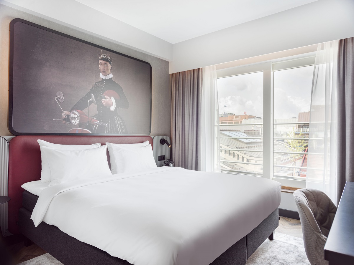 guestroom in Radisson RED Oslo with white bed linen and statement art above the bed