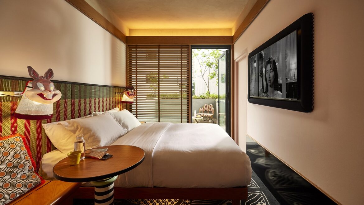 guestroom in MAMA SHELTER Singapore Small Mama Double with doors opening onto Terrace and masks on lights next to bed