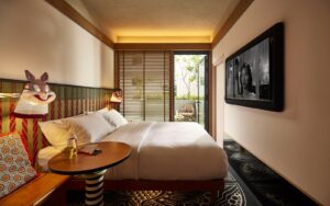 guestroom in MAMA SHELTER Singapore Small Mama Double with doors opening onto Terrace and masks on lights next to bed