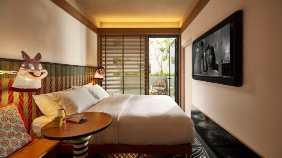 guestroom in MAMA SHELTER Singapore Small Mama Double with doors opening onto Terrace and masks on lights next to bed