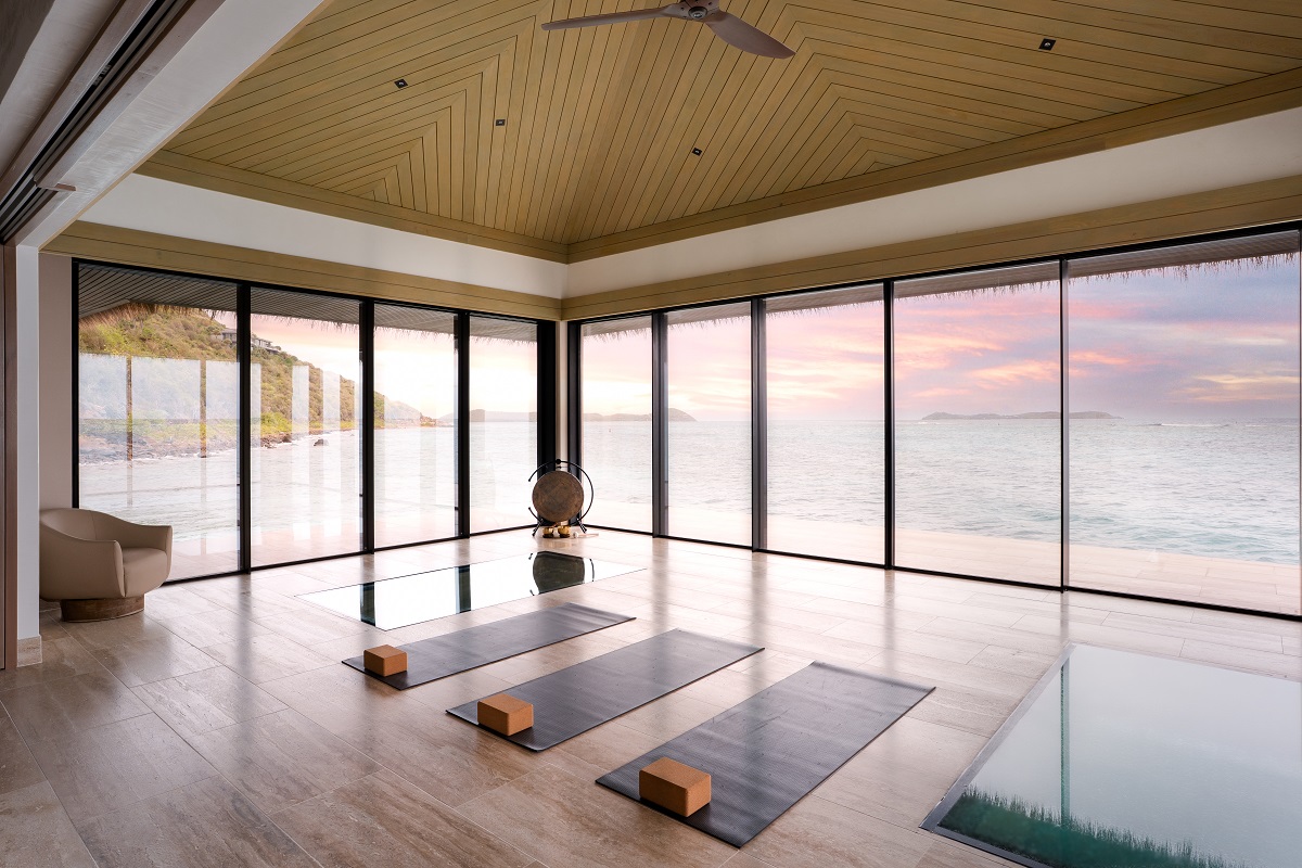 yoga mats in yoga room with floor to ceiling windows and views across the water