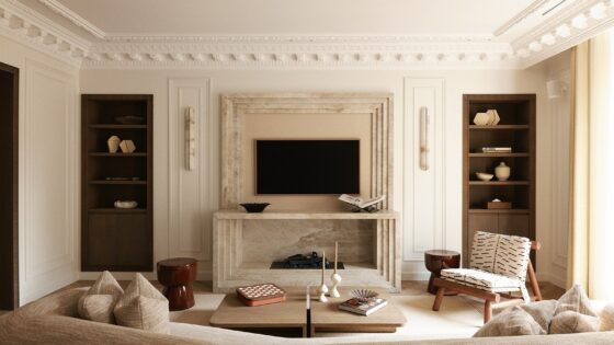 curved couch facing period fireplace in Parisian apartment decorated in neutral tones