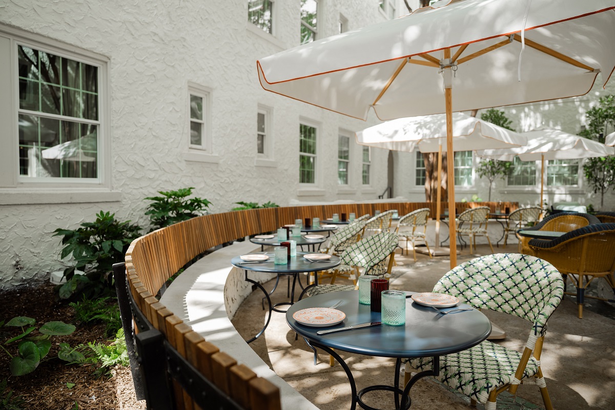 circular banquette seating in outdoor courtyard under umbrellas in Pom Court Hotel Granada
