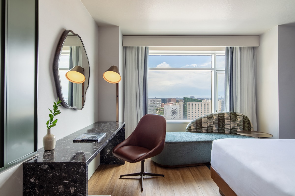organic shaped wall mirror above marble desk and vanity with city and mountain views from ne guestroom in Hyatt Regency Denver
