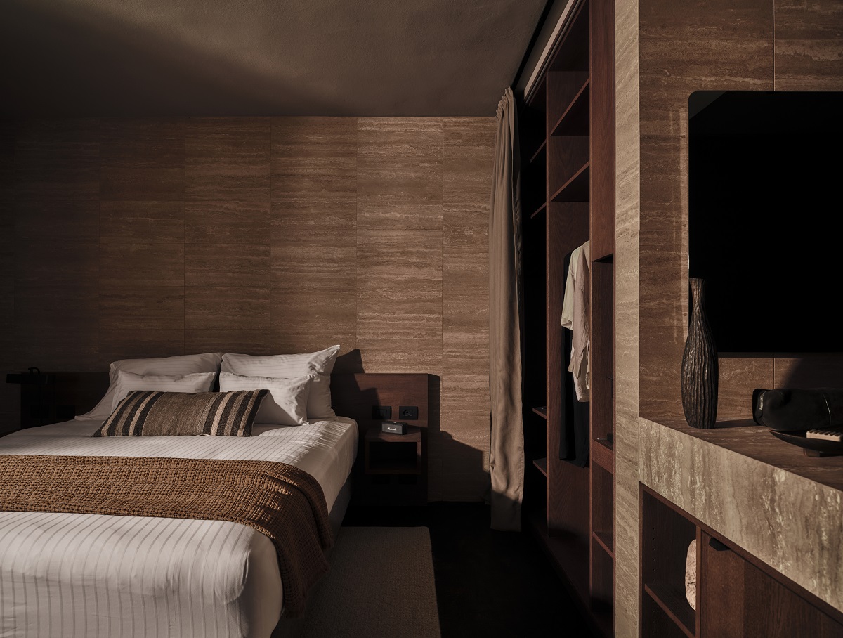 bedroom with ensuite bathroom vanity on the side all in warm tones of brown and natural textures