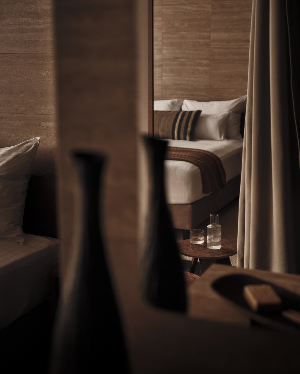 a view through curtains into guestroom and bed vignette