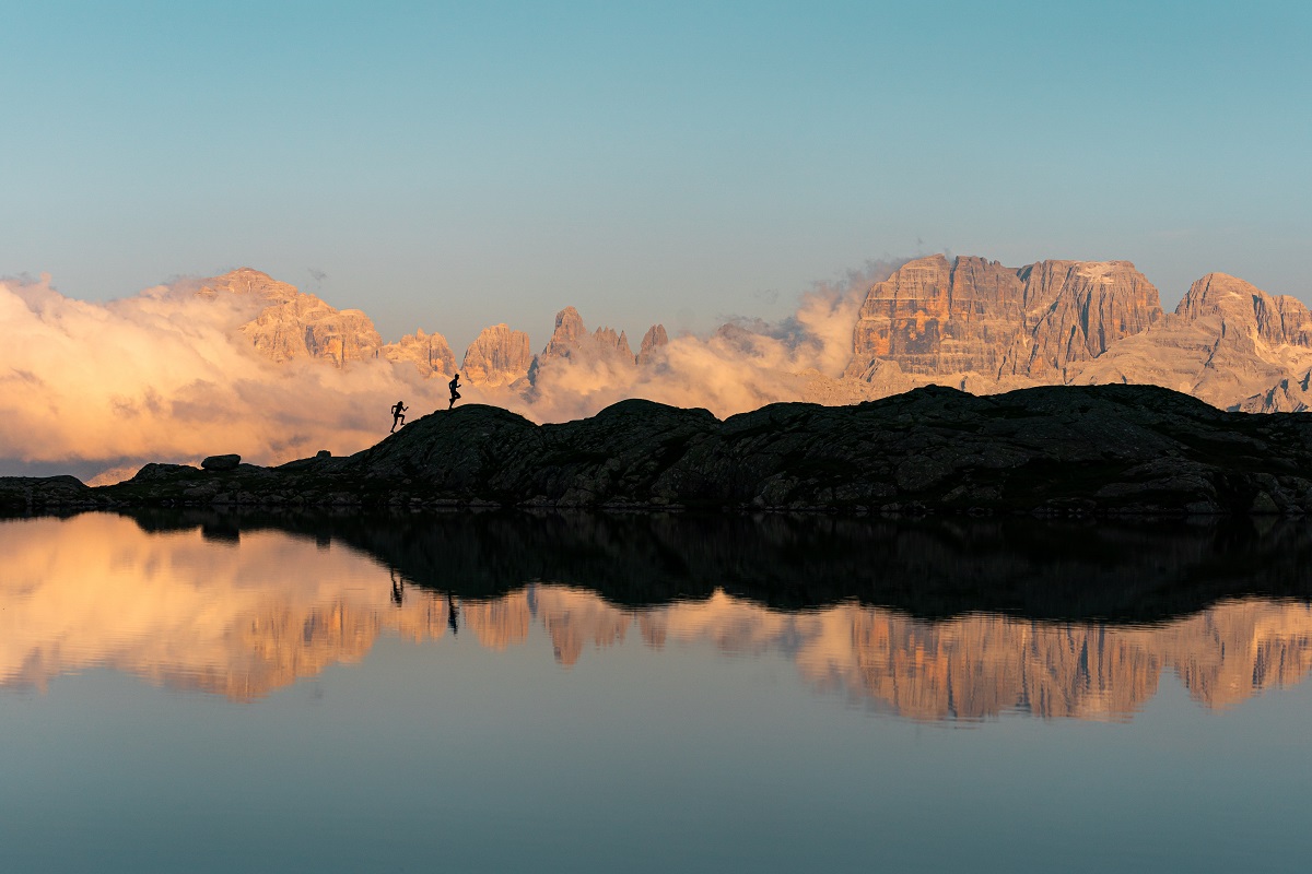 walking at sunset with mountains in profile - dolomites