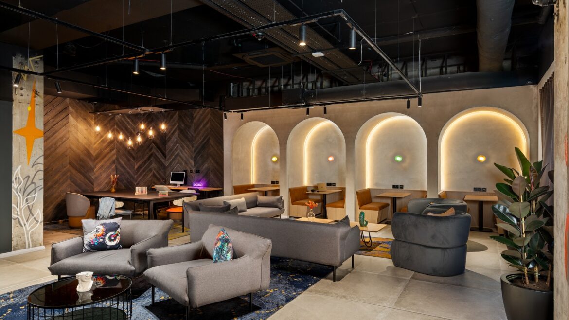 seating and tables in front of backlit arches in Moxy Belfast City - Lounge