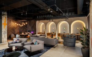 seating and tables in front of backlit arches in Moxy Belfast City - Lounge