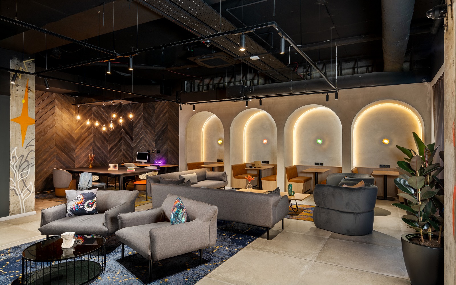 seating and tables in front of backlit arches in Moxy Belfast City - Lounge