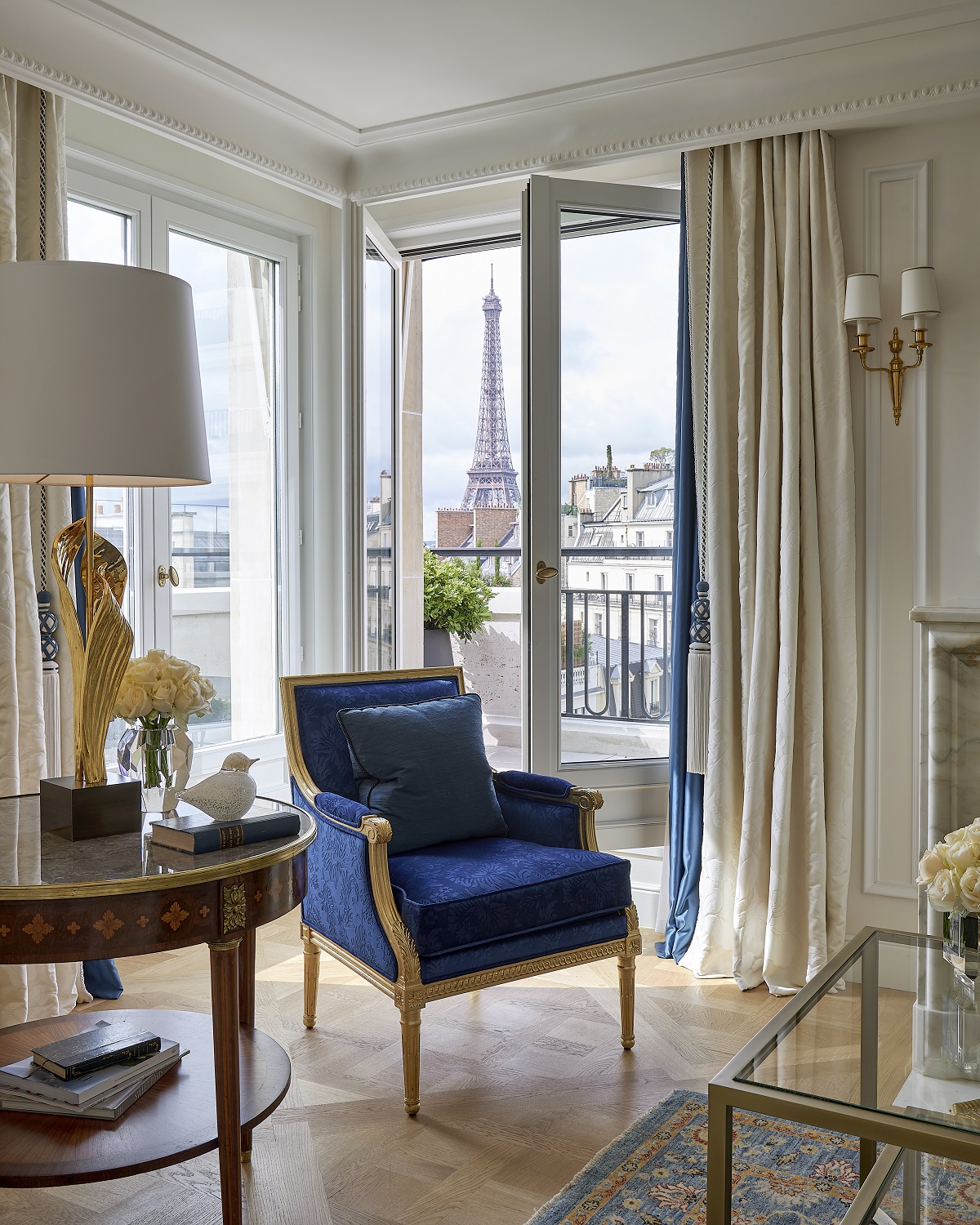 blue chair in front of window with view to eilffel tower in Four Seasons Hotel George V, Paris