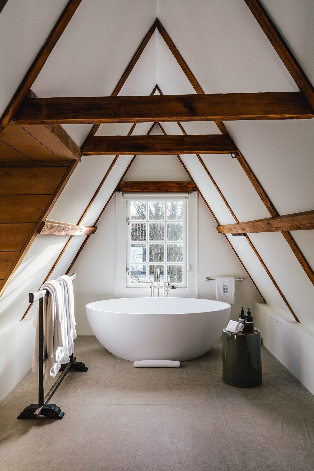 freestanding bath under exposed wooden beams in loft suite