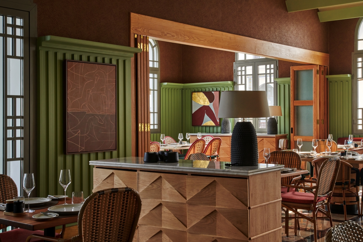 Double Decker curated art at Four Seasons Rabat. Green walled restaurant space with 3D wood details and earth toned artwork on the walls