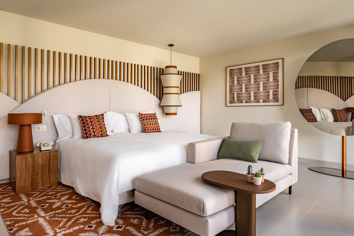 wooden panel feature behind double bed with white linen and coloured pillows