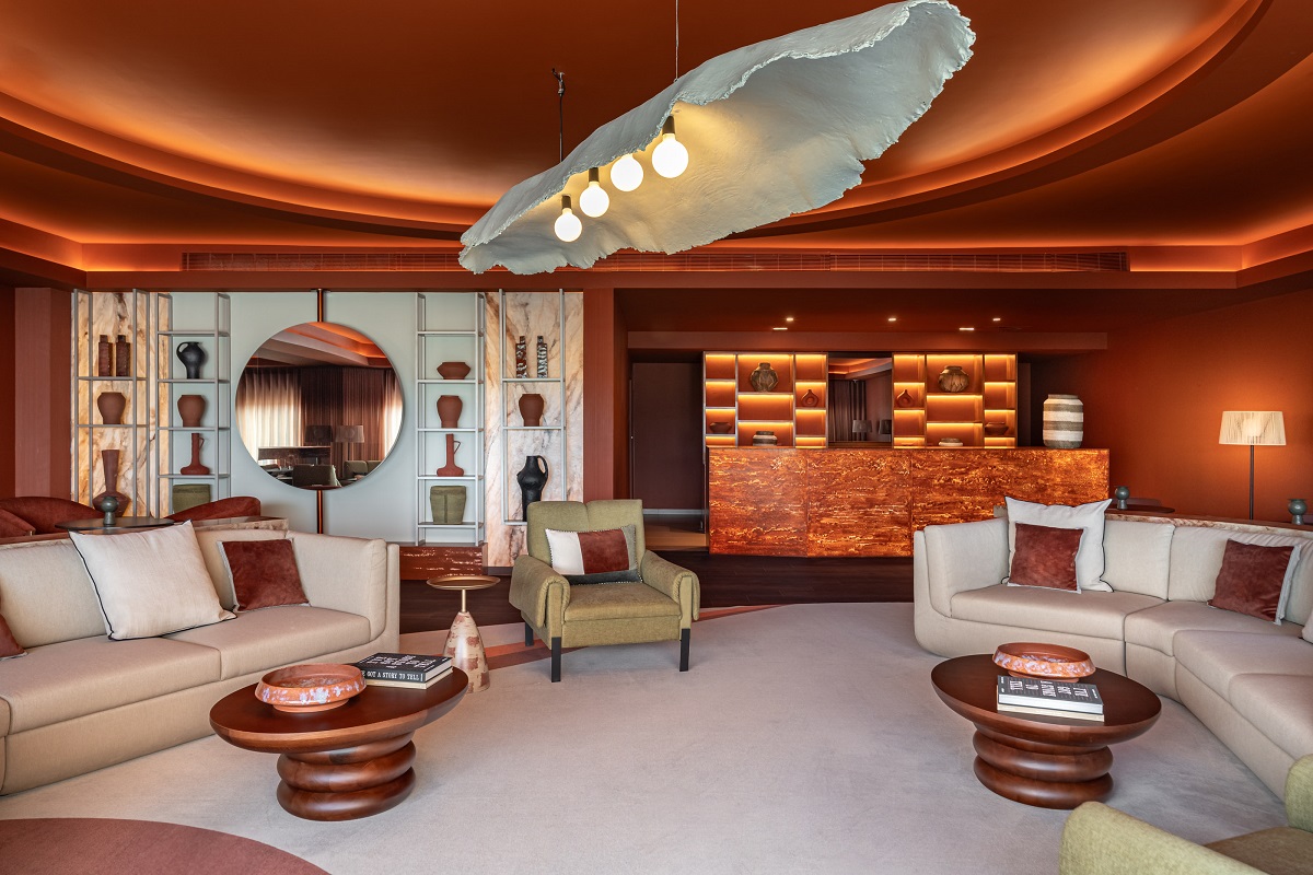couches below large ceramic pendant light with terracotta walls