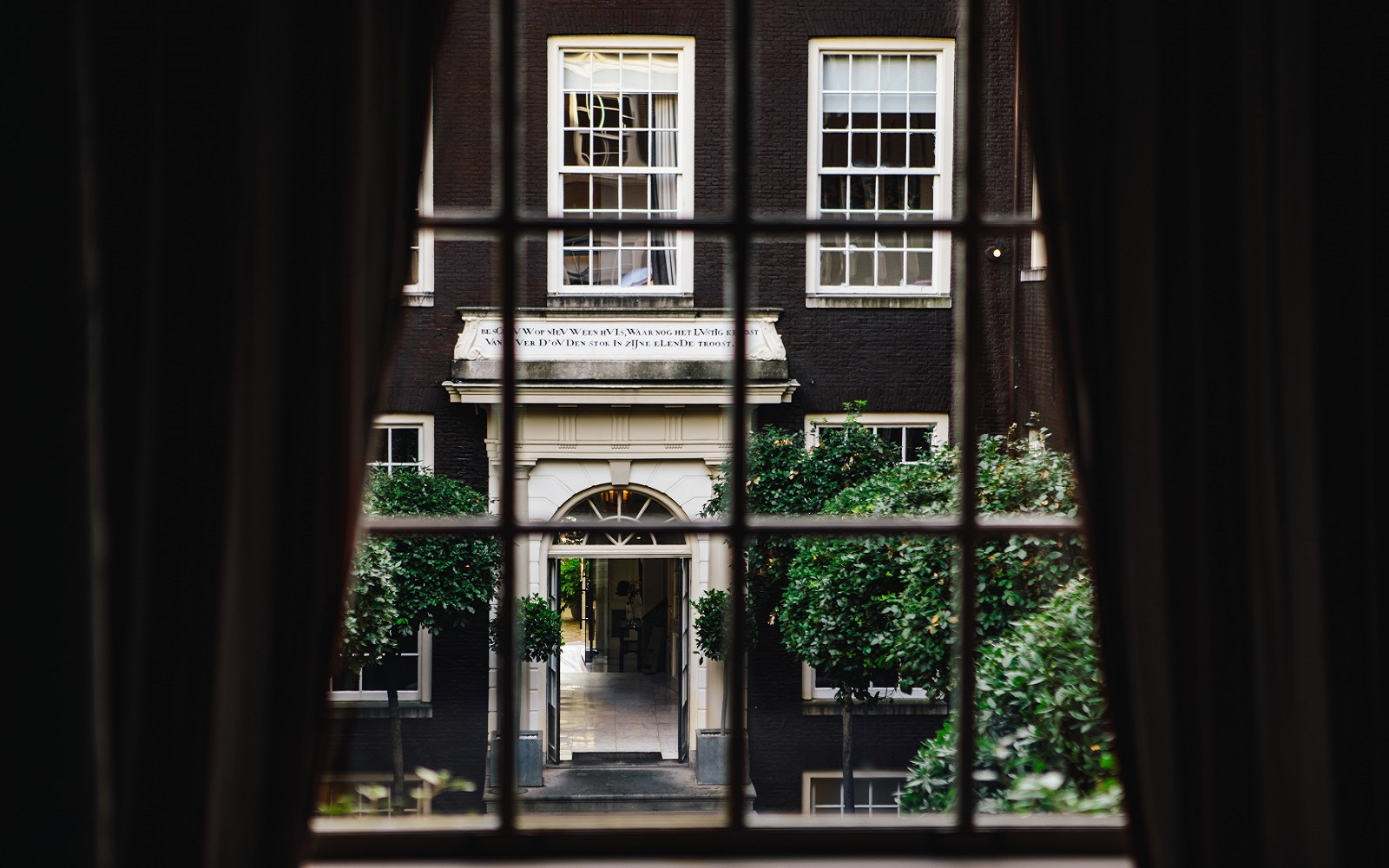 view of hotel entrance through curtains and window at The dylan amsterdam