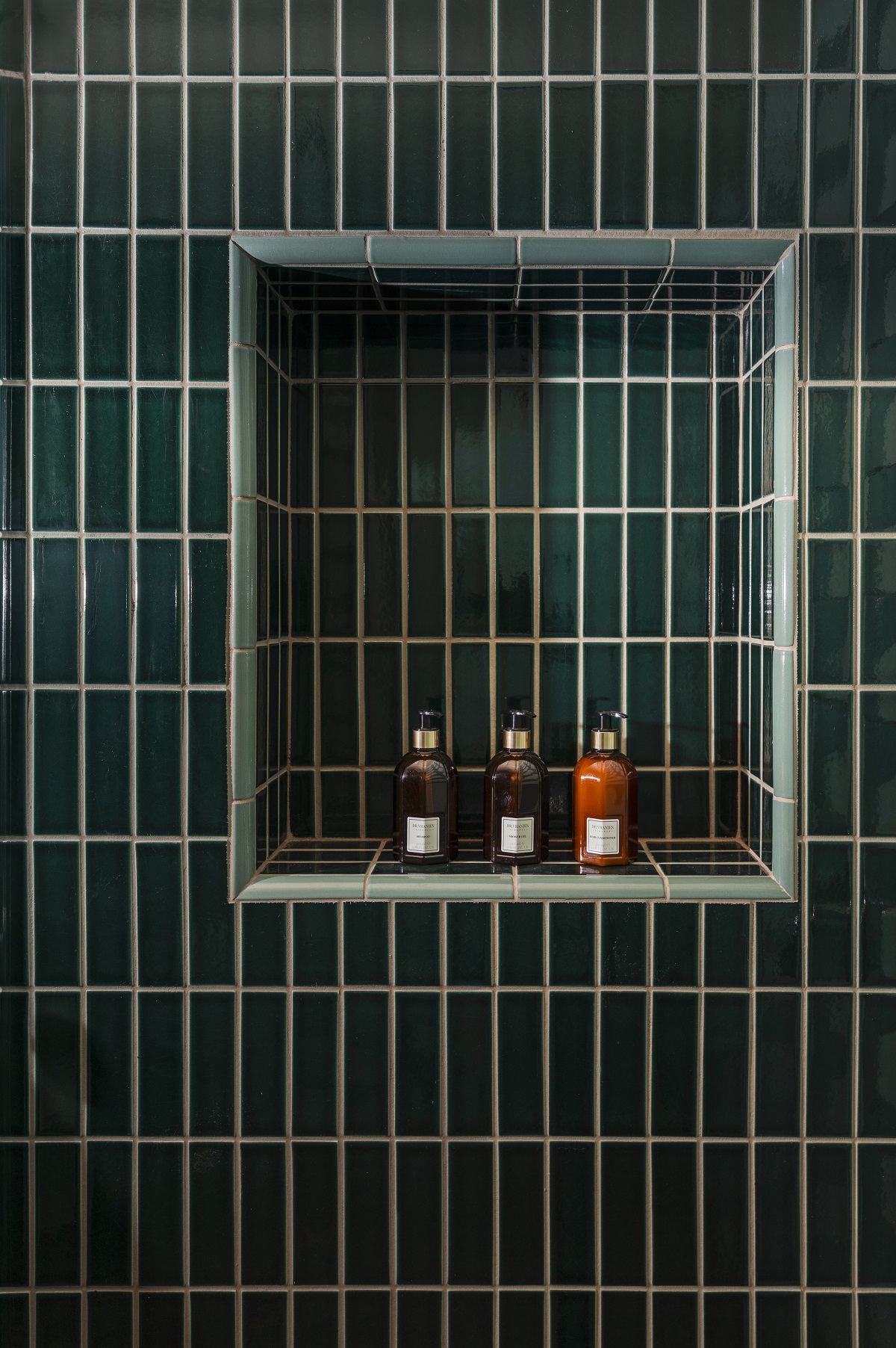 green tiled bathroom wall with tiled niche for product