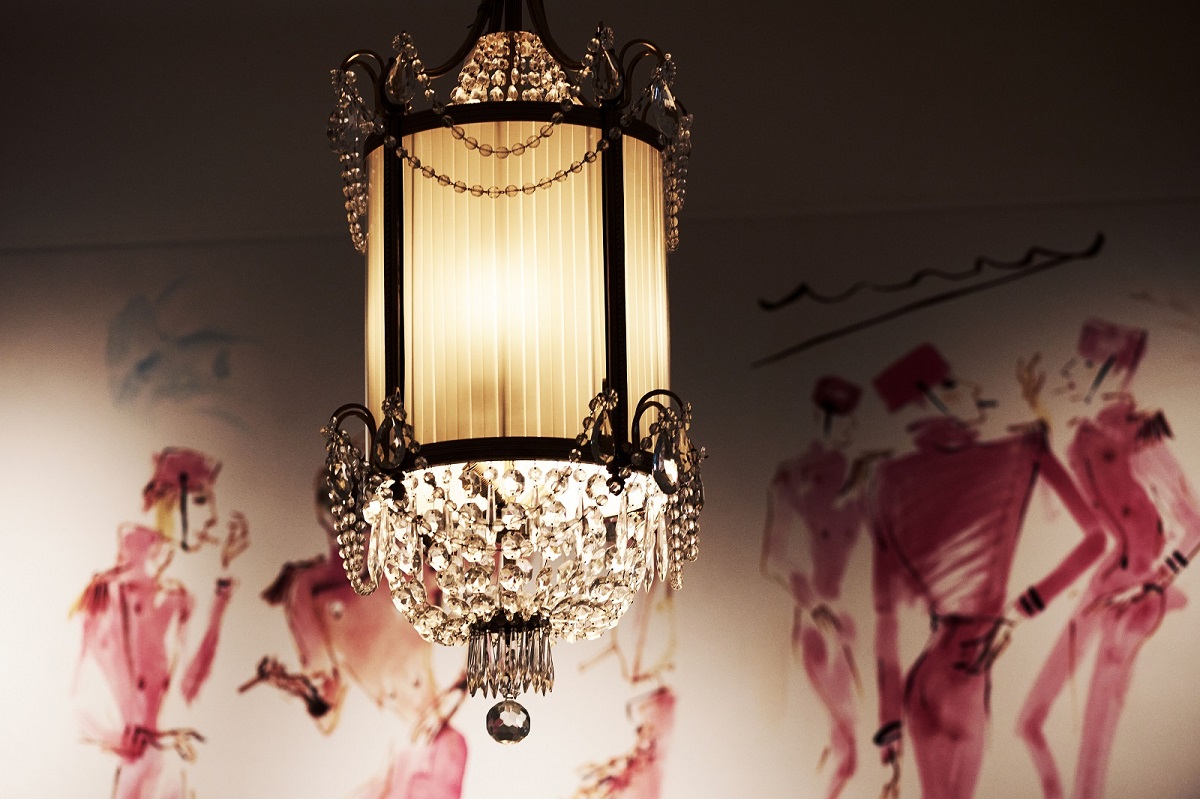 detail of vintage light with wall paintings by fashion illustrator Andrea Ferolla on the walls of hotel motto