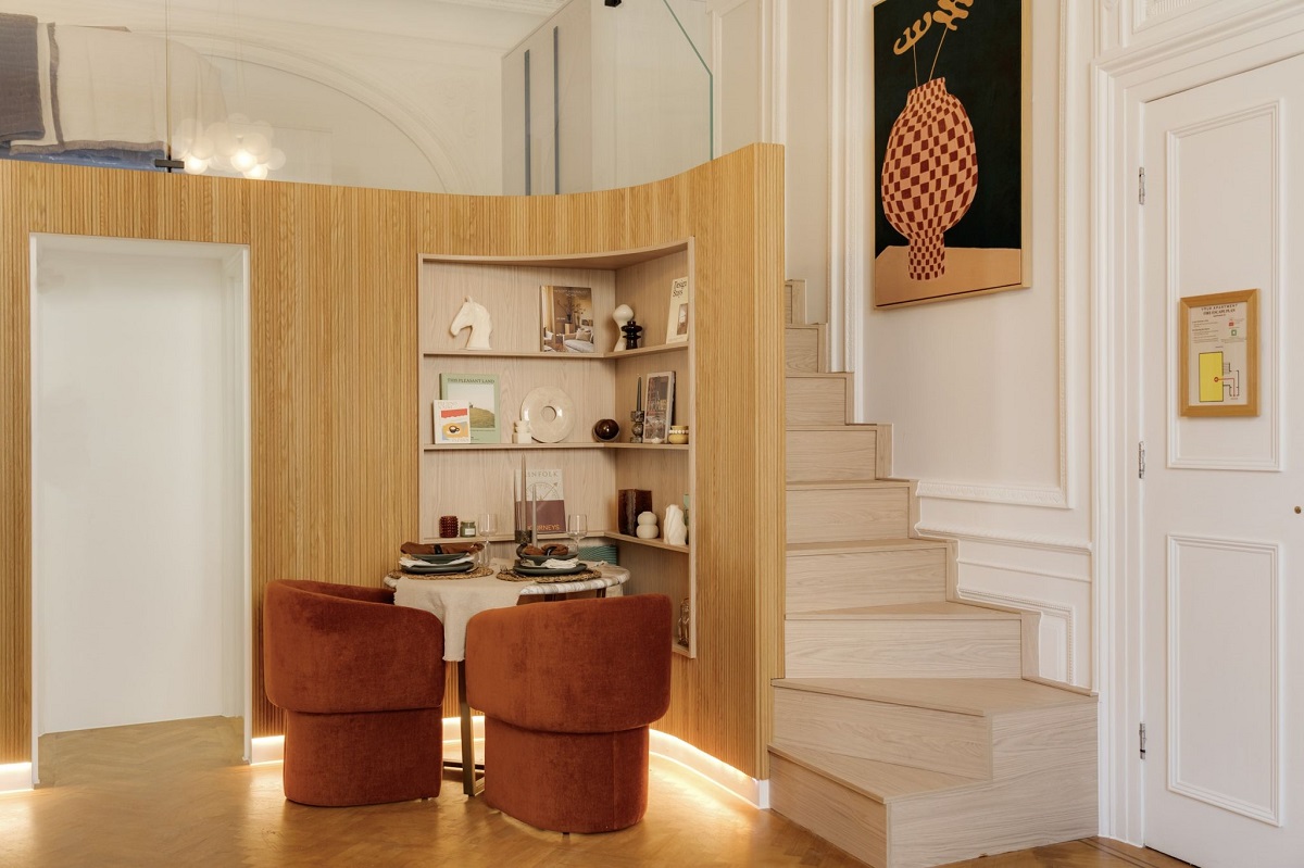 small round dining table alongside steps going up to mezzanine bedroom