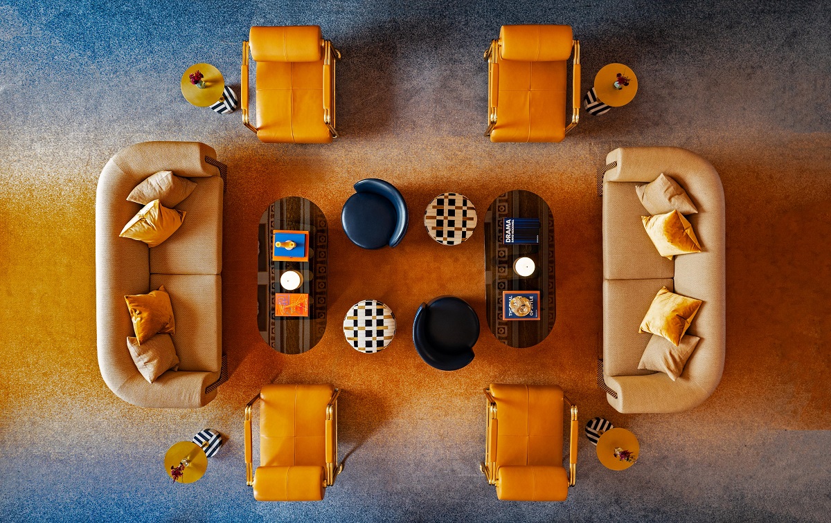 aerial view of W New York living room couches and chairs placed on orange and blue ombre carpet