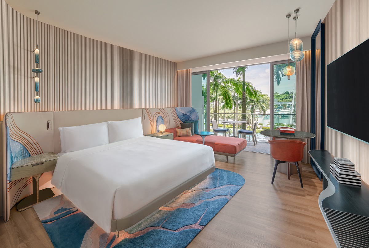 deluxe guestroom in Sentosa Singapore with doors opening onto terrace and tropical singapore foliage