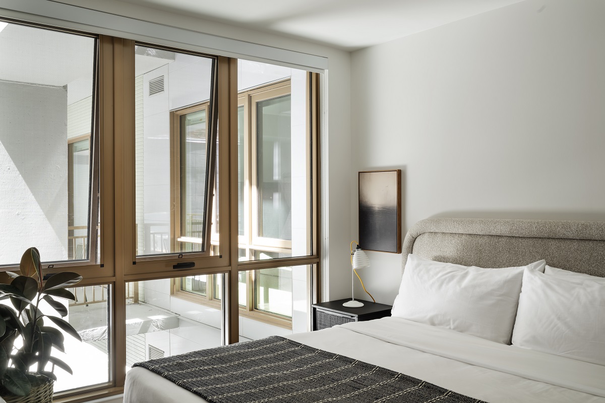 bedroom with plant and floor to ceiling window with view onto a private terrace