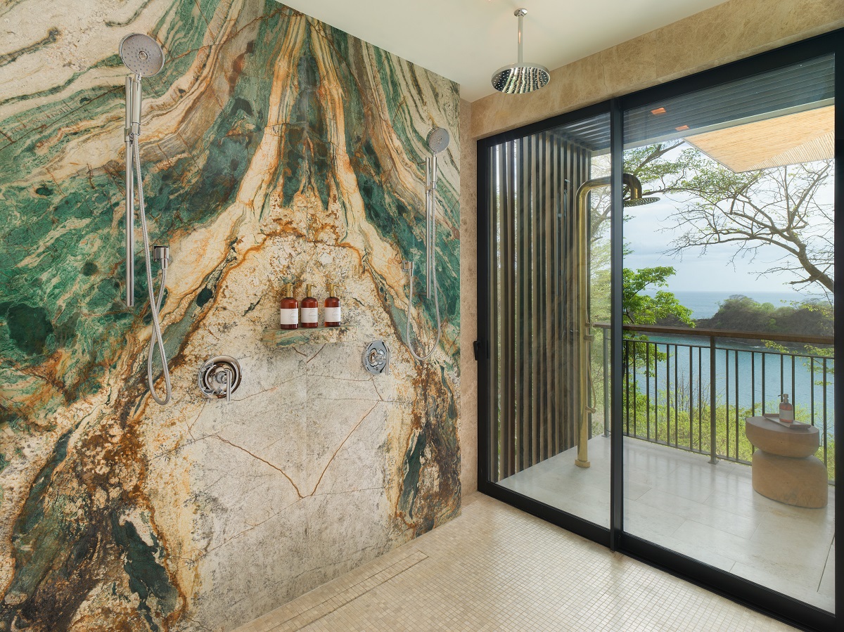 statement marble surface in green and brown in shower with view outside to terrace and ocean