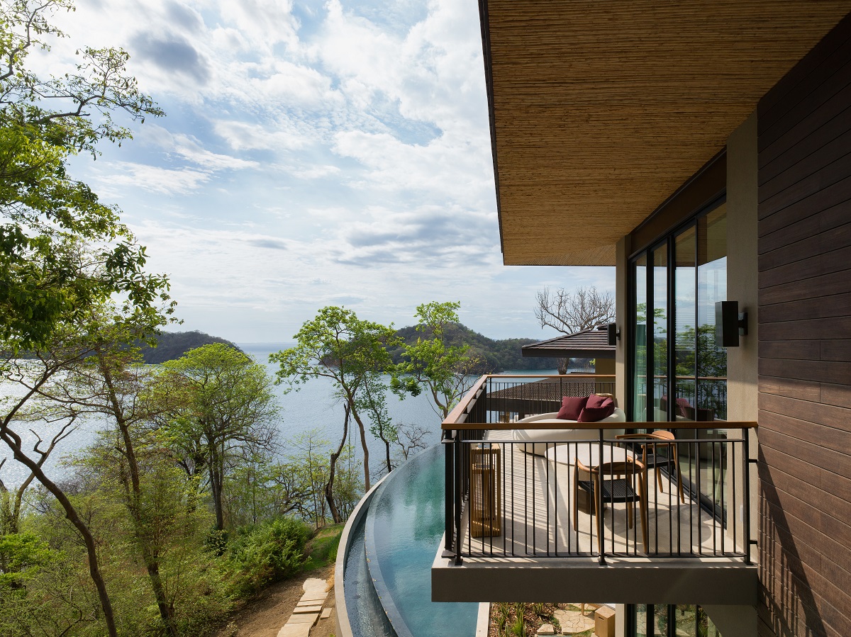 verandah overhanging infinity pool with ocean view and trees at ritz carlton residence 22 ar Nekajui